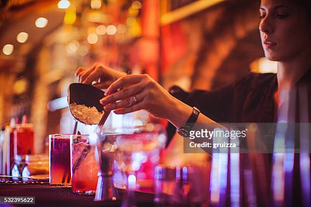midsection of young female bartender preparing cocktails in cocktail bar - barman stock pictures, royalty-free photos & images
