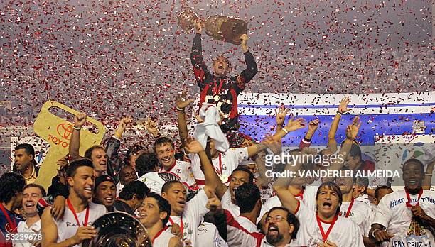 Sao Paulo's captain Rogerio Ceni , surrounded by teammmates, holds the Libertadores Cup trophy after winning the final against Atletico Paranaense,...