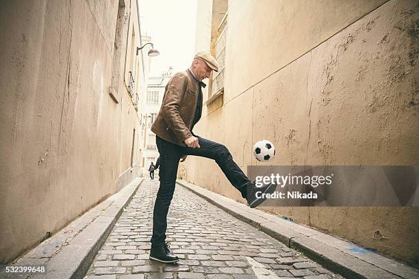 french man playing with soccer ball at urban street - guy kicking stock pictures, royalty-free photos & images