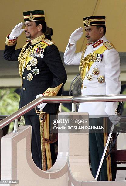 Bruneian Sultan Hassanal Bolkiah with Crown Prince Al-Muhtadee Billah salutes to a passing military contingent during his 59th birthday in Bandar...