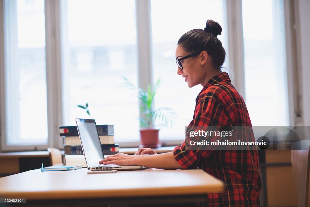 Young hipster girl working on laptop