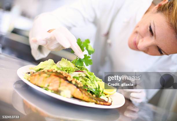 professional chef places finishing touches on meal - chefs whites stock pictures, royalty-free photos & images