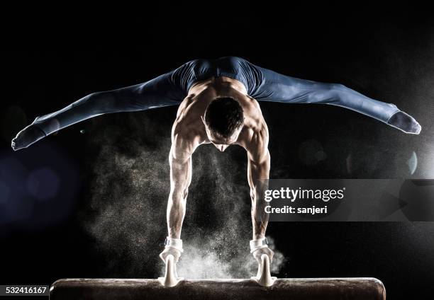 male gymnast doing handstand on pommel horse - gymnastics stockfoto's en -beelden