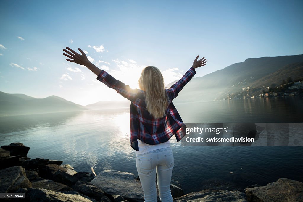 Freedom-Woman arms outstretched by the lake