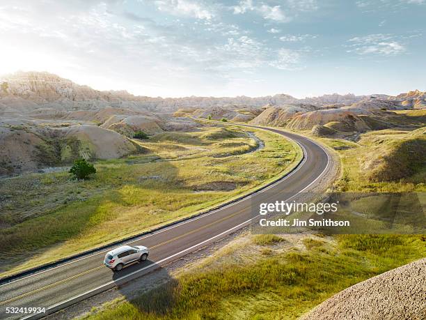 suv driving through the dramatic landscape of bandlands national park - thoroughfare stock pictures, royalty-free photos & images