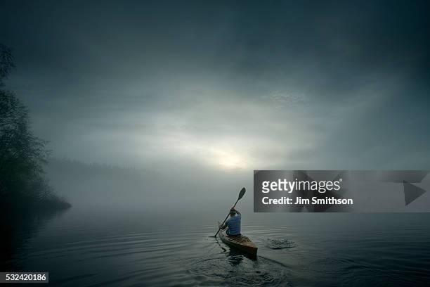 solitary kayaker paddling in calm waters. - kayak stock-fotos und bilder