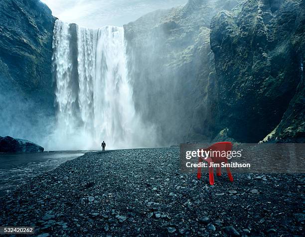 waterfall skogafoss red plastic chair in foreground - waterfall stock pictures, royalty-free photos & images