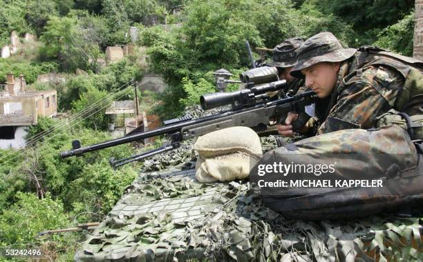 Serbia and Montenegro: German KFOR soldiers look through a sniper rifle securing the area during the visit of German opposition leader, head of the...