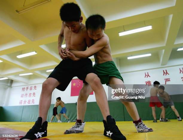 Zhong Ximing and Wang Xuelong, both 13 year-old, train during a wrestling course of Sports School of Dongcheng District on July 14, 2005 in Beijing,...