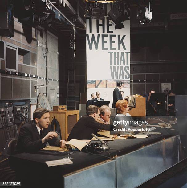 English broadcaster and journalist David Frost sits behind a desk with fellow presenters Lance Percival, Roy Kinnear and Millicent Martin on the set...