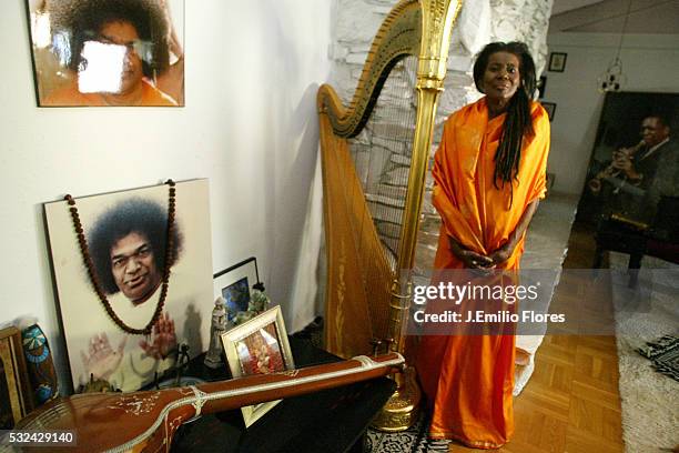 Alice Coltrane next to her religious shrine, with the portrait of her "guru" Satya Sai Baba. She explored the meditation ways since 1978 and she...