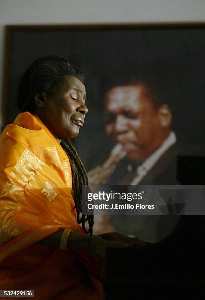 Alice Coltrane, wife of John Coltrane, plays the piano offered by her husband in 1964 in her California home. Alice has been practicing music since...