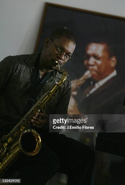 Ravi Coltrane in front of a photograph of his father john Coltrane at his mother Alice's home.