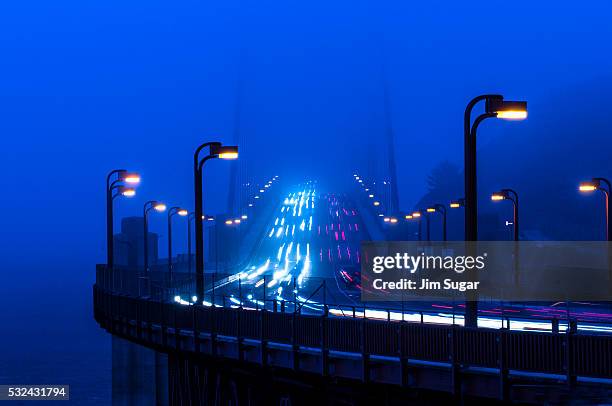 rush hour traffic crossing golden gate bridge - golden gate bridge night stock-fotos und bilder