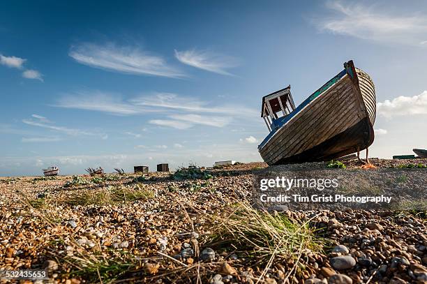 old abandoned fishing boat on the shingle beach, dungeness, kent, uk - dungeness stockfoto's en -beelden