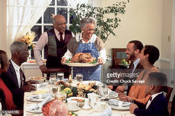 african american family enjoying thanksgiving dinner - spread joy stock pictures, royalty-free photos & images