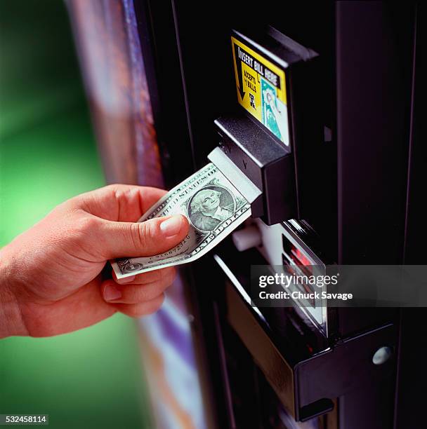 placing dollar in vending machine - equipamento acionado por moeda imagens e fotografias de stock