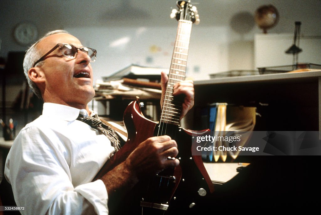 Businessman playing electric guitar