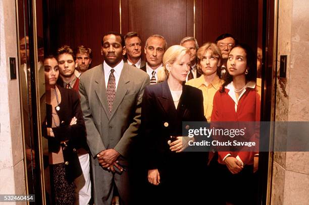 executives crowded into elevator - elevator fotografías e imágenes de stock