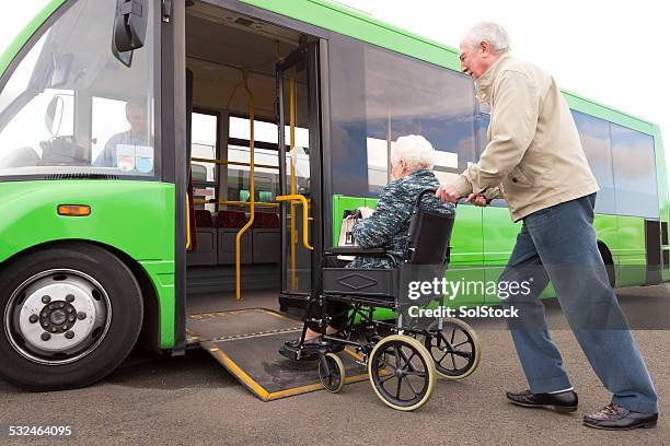 senior pareja contrayendo en autobús a través de la rampa para silla de ruedas - montar un vehículo fotografías e imágenes de stock