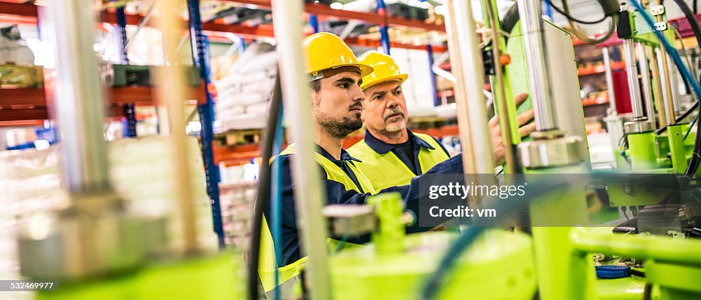 Industrial Workers Controling Machine in the Factory