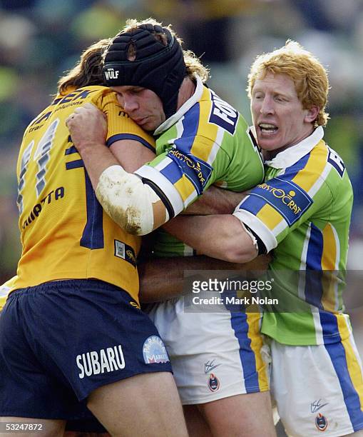 Troy Thompson of the Raiders gets assistance from team mate Alan Tongue during the round 19 NRL match between the Canberra Raiders and the Parramatta...