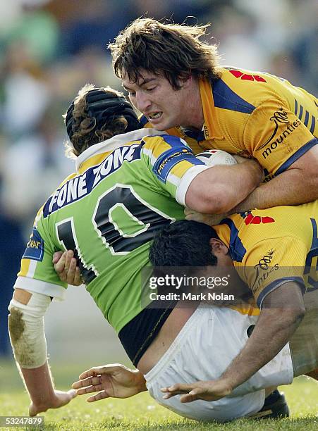 Nathan Cayless and Dean Widders of the Eels tackle Troy Thompson of the Raiders during the round 19 NRL match between the Canberra Raiders and the...