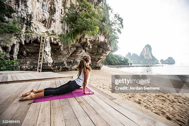 a woman doing yoga. - beach yoga stock-fotos und bilder