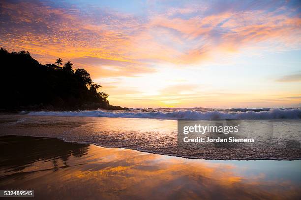 sunsetting over a tropical beach. - provincia-di-phuket foto e immagini stock