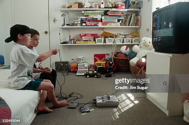 boys playing video games in playroom - 90s tv set stock pictures, royalty-free photos & images