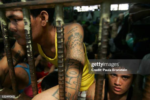 Filipino inmate peers out from his overcrowded cell at the Navotas Municipal jail July 17, 2005 in Navotas, Manila, Philippines. Economic woes have...