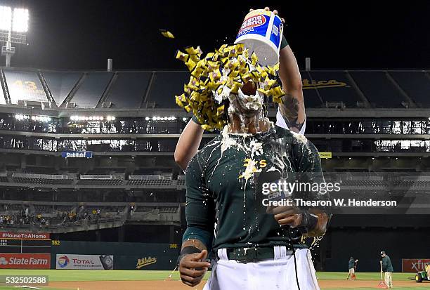 Khris Davis of the Oakland Athletics is showered with bubble gum by Yonder Alonso after Davis hit a walk off grand slam home run against the Texas...