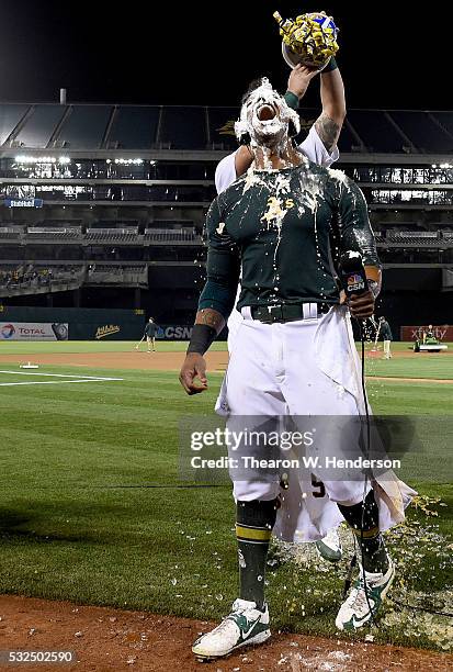 Khris Davis of the Oakland Athletics is showered with bubble gum by Yonder Alonso after Davis hit a walk off grand slam home run against the Texas...