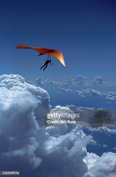 hang glider flying above clouds - paragliding stockfoto's en -beelden