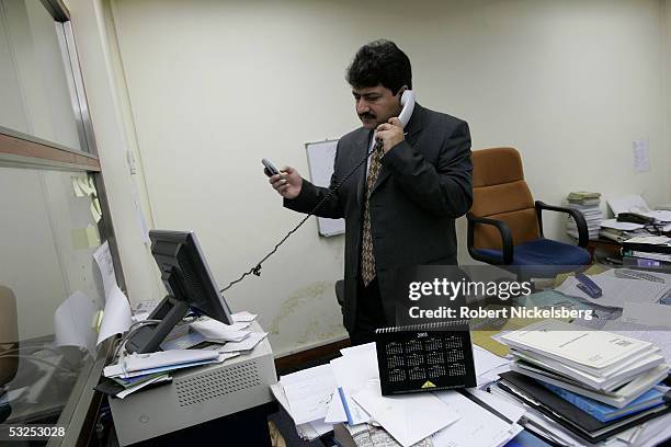 Geo TV's Islamabad Bureau Chief Hamid Mir speaks on a phone to one of his northern Pakistan's correspondents from his office January 18, 2005 in...