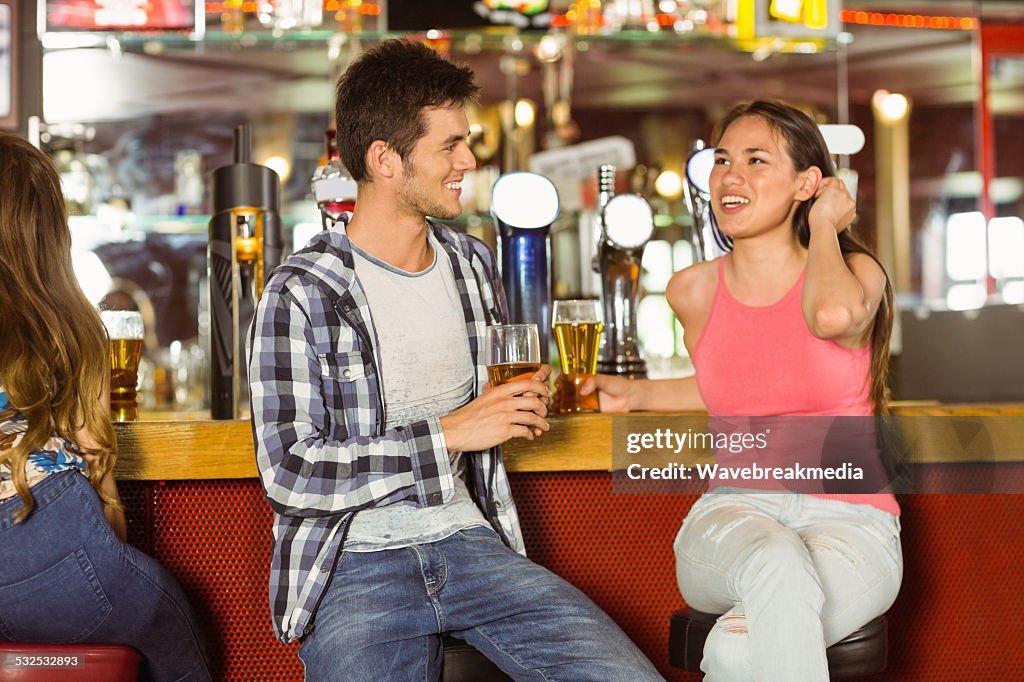 Sorrindo amigos, bebendo cerveja juntos