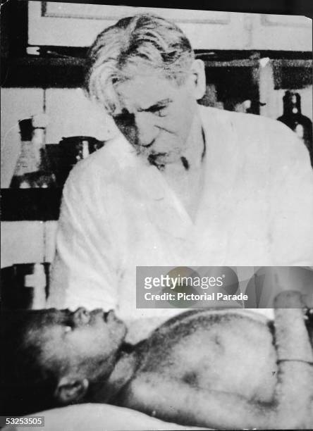 Alsatian theologian, physician, and medical missionary Dr. Albert Schweitzer tends to a young patient at the hospital he founded at Lambarene, French...