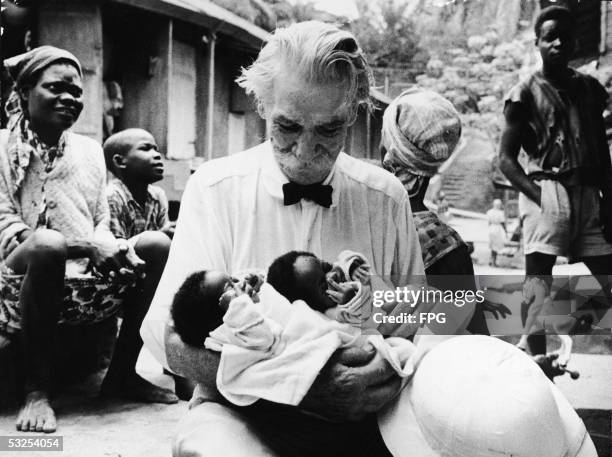 Alsatian-born German theologian, musician, physician, and medical missionary Albert Schweitzer holds two newborn babies at the hospital he founded in...