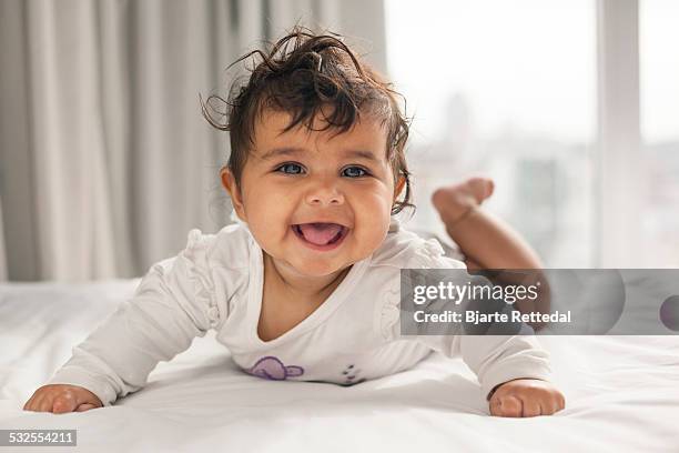 laughing baby on the bed - weibliches baby stock-fotos und bilder
