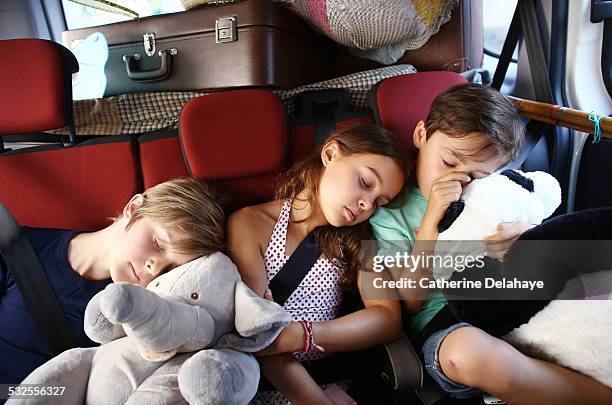 3 children sleeping in a car - sleeping in car foto e immagini stock