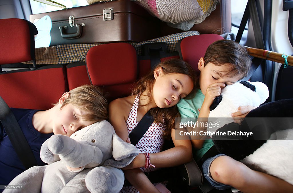 3 children sleeping in a car