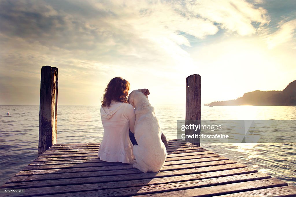 Dog rests gently on his master's shoulder while looking view