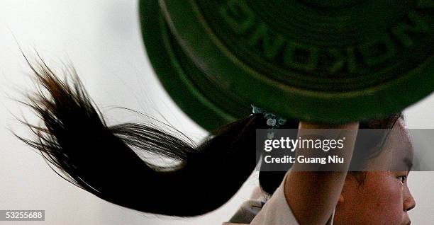 Dong Lingyu trains during a weightlifting course at a Sports School in the Dongcheng District on July 19, 2005 in Beijing, China. The school was...