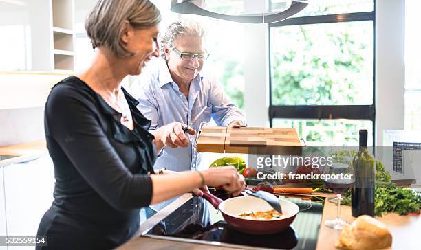 anstrengenden älteres paar kochen in der küche - middle aged couple cooking stock-fotos und bilder