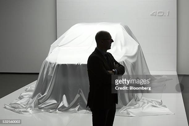 Visitor stands near a covered Volvo 40.1 concept automobile ahead of its unveiling at a media event at the headquarters of Volvo Car Group in...