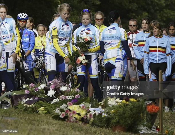 Unidentified female cyclists lay flowers beside a wooden cross at the site of a fatal accident involving some of Australia's top women cyclists near...