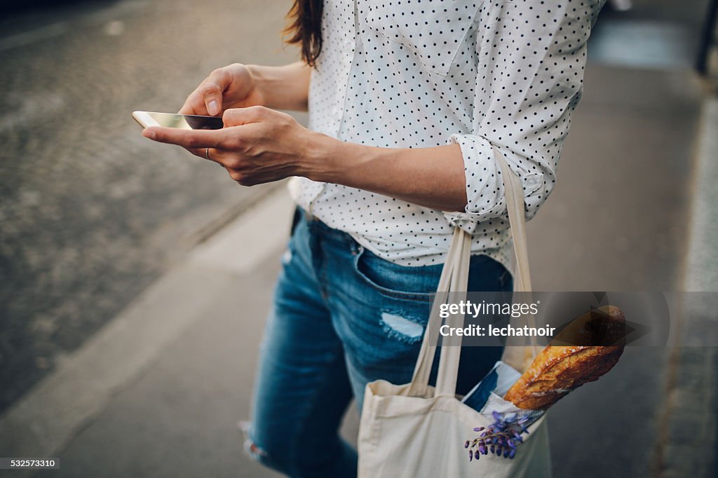 Jovem parisiense mulher a utilizar o smartphone