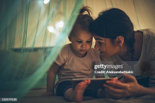 choosing her favourite bedtime ebook - fairy tale 個照片及圖片檔
