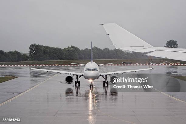 plane waiting for take off in the rain - taxiing stock pictures, royalty-free photos & images