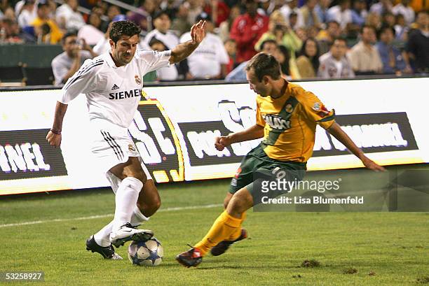 Luis Filipe Figo of the Real Madrid dribbles against the defense of Michael Enfield of the Los Angeles Galaxy during the game at the Home Depot...